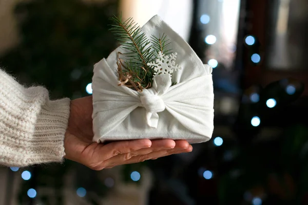 手里拿着圣诞礼物包装在生态友好的材料 Furoshiki面料 Bokeh 有选择的重点 — 图库照片