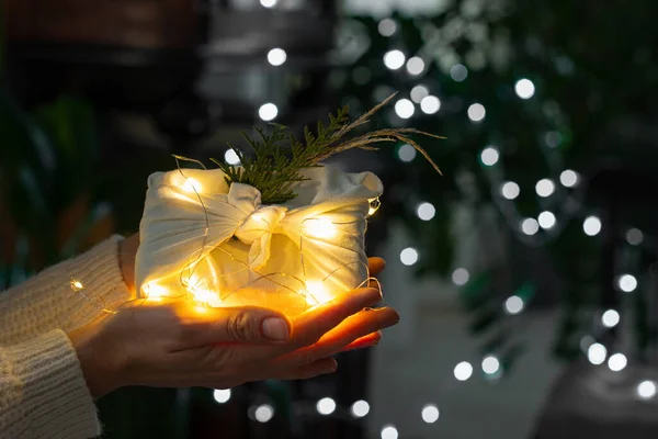 手里拿着圣诞礼物包装在生态友好的材料 Furoshiki面料 Bokeh 有选择的重点 — 图库照片