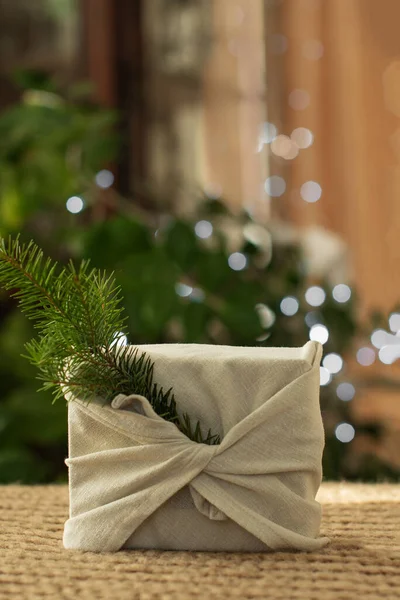 Regalo de Navidad. Embalaje en materiales ecológicos, tela furoshiki. Bokeh, enfoque selectivo — Foto de Stock