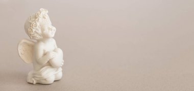 Pembe arka planı olan melek bir aşk tanrısı figürü. Sevgililer Günü.