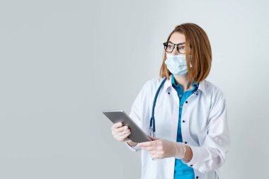 Hastanedeki dijital tablet uzaktan kumandalı teletıp uygulamasını kullanan profesyonel doktor. Sağlık teknolojisi tele sağlık e-sağlık konsepti. Görüntüyü kapat, boşluğu kopyala.