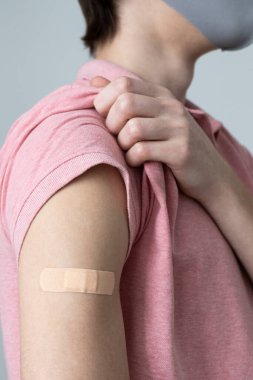 Çekici, güzel bir adam ya da genç bir kız kampanya aşısında covid-19 antivirüs aşısı oldu. Kollarında bandaj ve fotokopi alanı vardı.