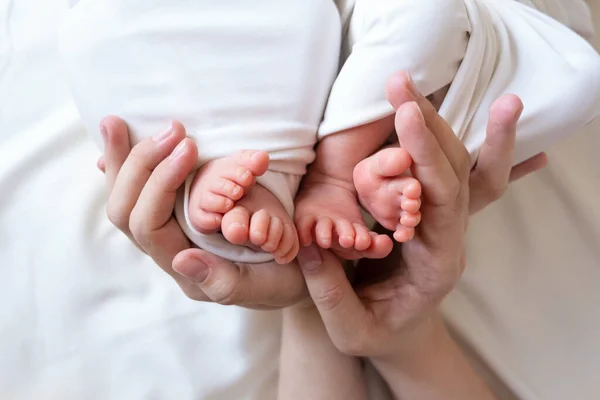 Mama en papa handen houden kleine benen van hun twee pasgeboren tweeling baby 's — Stockfoto