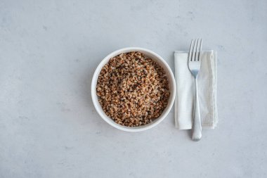 Minimalist tarzda gri beton arka planda bir kase karabuğday. Sağlıklı gıda kavramı. 