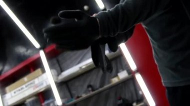 Adam garajda araba cilası sürmeden önce siyah lastik eldiven takıyor. Araba servis istasyonu çalışanı. Düşük açı. Yakın çekim..