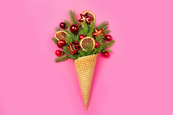 ピンクの背景にクリスマスツリーとおもちゃの小枝とアイスクリームコーン クリスマスカード コピースペース フラットレイアウト コンセプト写真はオリジナルクリスマスプレゼント — ストック写真