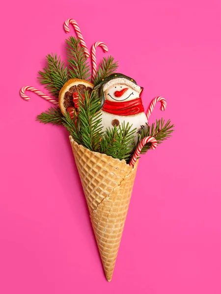 圣诞树枝条和棒棒糖在一个华夫饼锥 粉色背景 圣诞卡甜蜜的礼物 — 图库照片