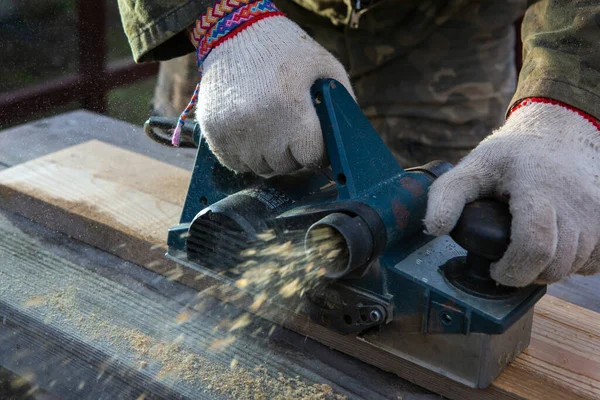 与电动刨床接合的手 一个专业人员的工作木制品 — 图库照片