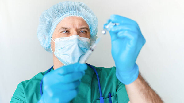 Vaccination against COVID-19. A doctor wearing a mask and gloves draws a coronavirus vaccine into a syringe to vaccinate a patient. The concept of planned annual vaccination and immunization.