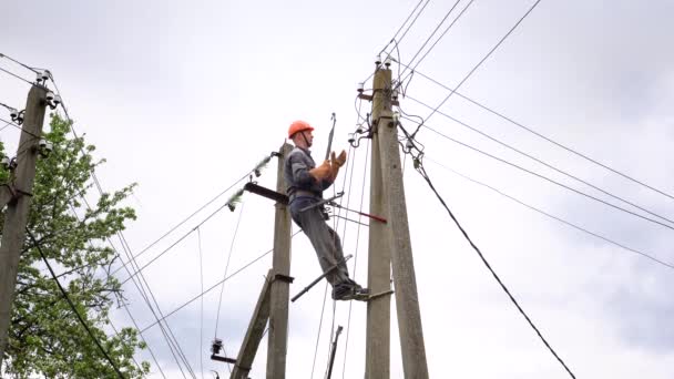 De elektricien verbindt de verlichtingskabel in het dorp. — Stockvideo