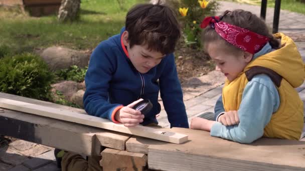 Barn gör kreativt arbete utomhus en solig dag. — Stockvideo