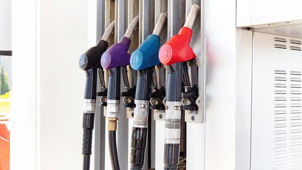 Fuel dispensing guns at a gas station for different types of gasoline close-up. Fluctuations in the cost of fuel prices concept. Petroleum products.