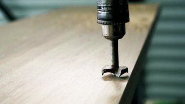 Çizgili tahtaya mobilya yerleştirmek için delik açmak. DIY. Mobilya yapmak.