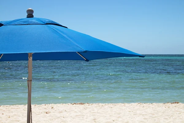 Зонтик на белом песчаном пляже — стоковое фото