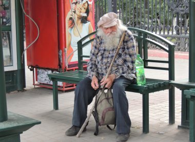 Bir otobüs durağı bankta oturan üst düzey yetişkin adam