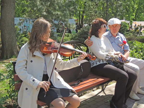 The girl play the fiddle in the city square on the V-E Day — Stock Photo, Image