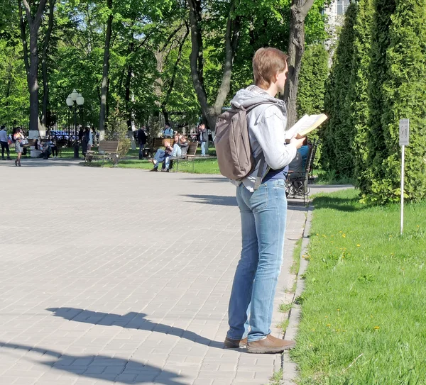 Standing young men reading a book while standing — Stock Photo, Image