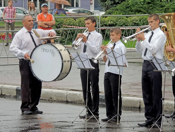 Performance of children's brass band beating in the rain — Stock Photo, Image