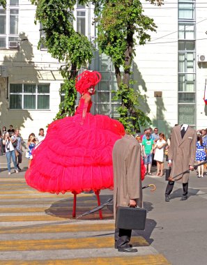 Gentlemans başkanları ve aktris stilts üzerinde Kırmızı elbiseli olmadan 