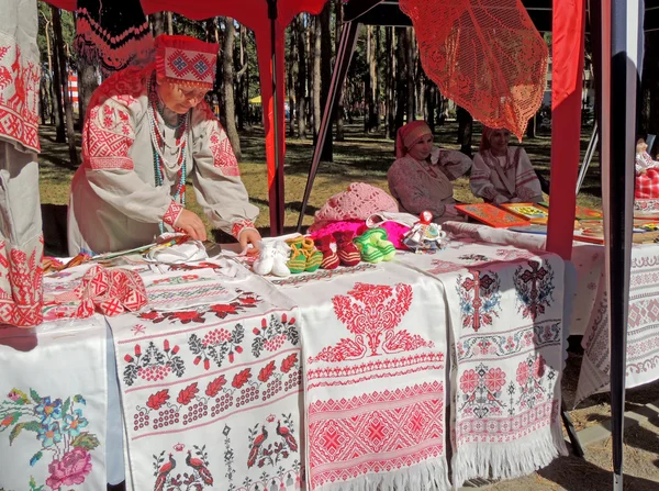 Стол с ремесленными рушниками и вязаными изделиями — стоковое фото