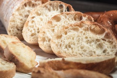 Ahşap bir tahtanın üzerinde çeşitli köy ekmekleri. Sağlıklı gıda ve tarım kavramı