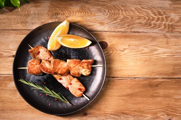 Salmón a la parrilla en un pincho en un plato oscuro está sobre la mesa. Concepto de comida saludable — Foto de Stock