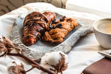 İş planı için ayçöreği, boş not defteri ve kurşun kalemle kahve fincanı yukarıdan beyaz bez, hoş ve lezzetli bir kahvaltı, kaliteli bir ton.