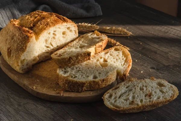 Olika rustika bröd på en träskiva. Friska livsmedel och odlingskoncept — Stockfoto