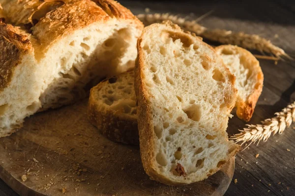 Olika rustika bröd på en träskiva. Friska livsmedel och odlingskoncept — Stockfoto