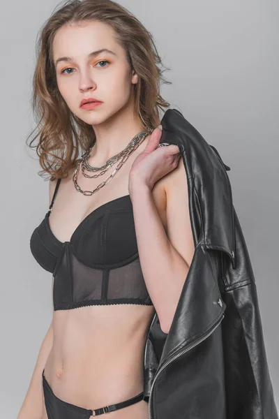 Young, beautiful woman in a swimsuit and jacket in the studio on a gray background. The concept of style and fashionable clothes — Stock Photo, Image