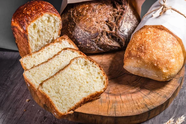 Różny rustykalny chleb na drewniany tablica. Koncepcja zdrowej żywności i rolnictwa — Zdjęcie stockowe