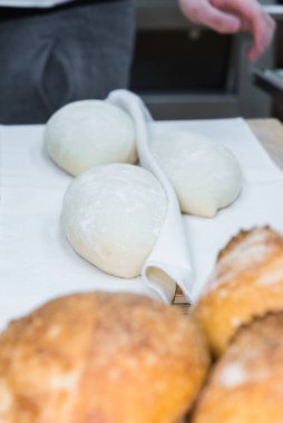 Fırıncı ekmek yapıyor, erkek eli, hamur yoğuruyor, manto pişiriyor. Küçük fırın kavramı, geleneksel ekmek sanatı.