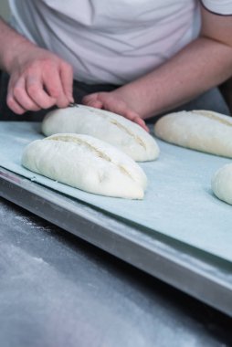 Fırıncı ekmek yapıyor, erkek eli, hamur yoğuruyor, manto pişiriyor. Küçük fırın kavramı, geleneksel ekmek sanatı.