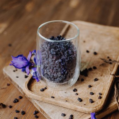 Tahta masadaki bir bardakta kurumuş yabanmersini.