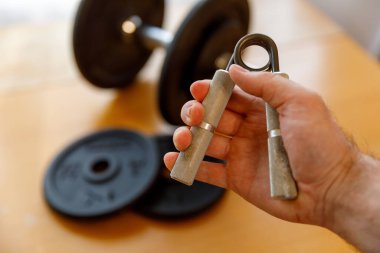 Metal genişletici elinde. halterlerin arka planına karşı