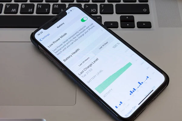 MOSCOW / RUSSIA - 4 Nisan 2020: iPhone 11 Pro bir MacBook klavyesinde yer almaktadır. Pil koruyucu kipini ayarlamak için menü ekranında