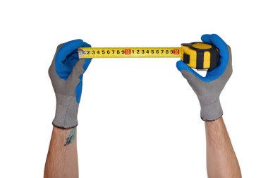 Eldivenli bir adam elinde bir metreyle mezura tutuyor.