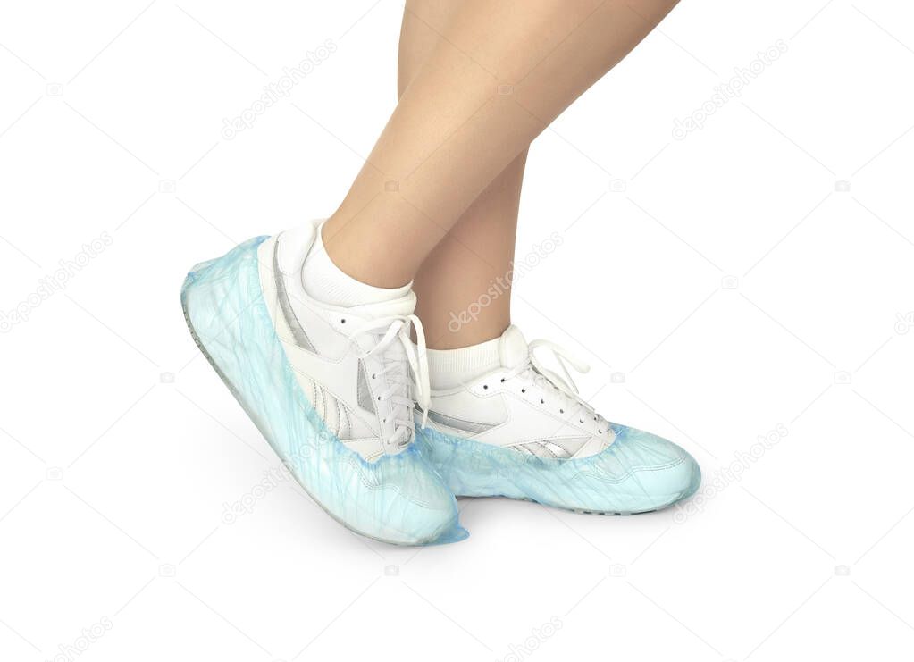 Woman with blue shoe covers worn over sneakers on white background, closeup