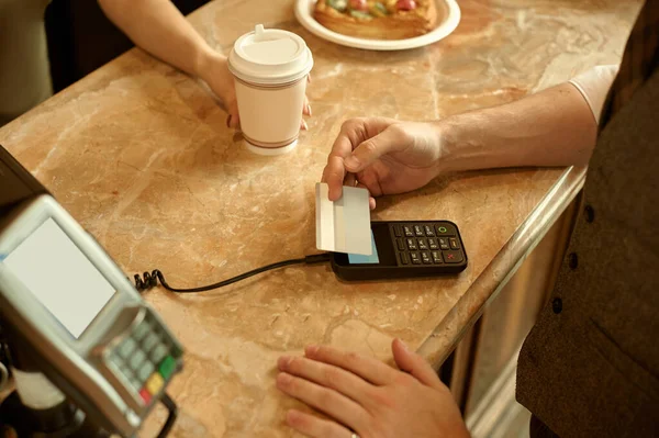 customer paying with credit card in cafe.