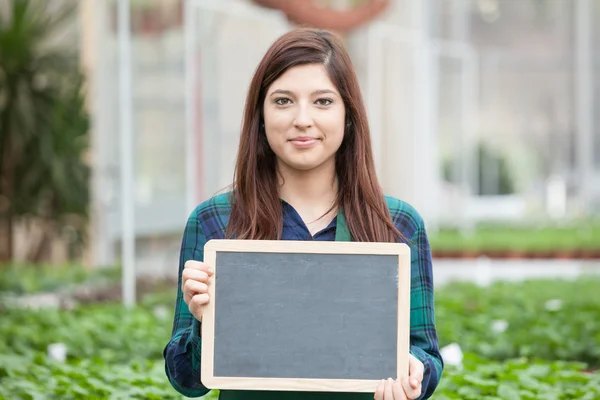 Garden worker holding chalkboard — Stock Photo, Image
