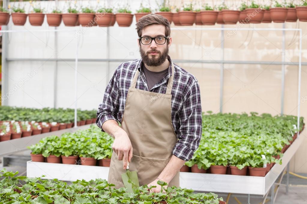 Young florist  in greenhouse