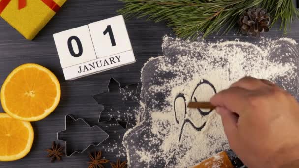 2021年のクリスマスや年末年始のお祝いの御馳走を準備するために小麦粉に碑文を作る 1月1日の平置きカレンダー クッキー型と小麦粉 — ストック動画