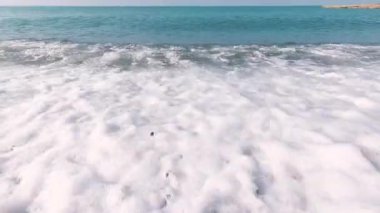 Deniz dalgasının gelgiti. Su küçük çakıl taşlarının üzerine yayılır.