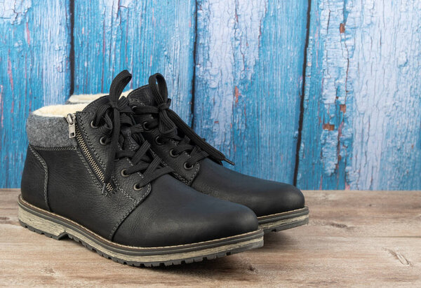 leather insulated boots on a wooden background
