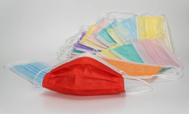 Kırmızı cerrahi koruyucu maske. Beyaz arka planda tıbbi solunum bandajı var. Corona virüsüne karşı korunmak için çok renkli antiviral maske. 