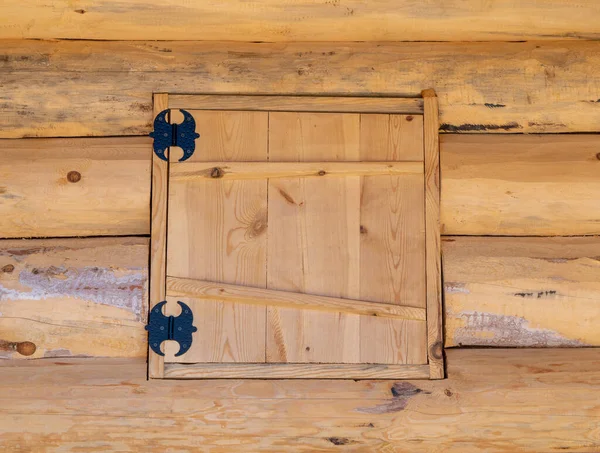 Escotilla cuadrada en la pared de madera. la puerta está hecha de madera — Foto de Stock