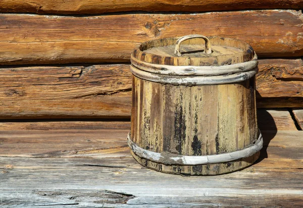 old wooden tub with lid. container made of wooden planks and covered with hoops. vintage barrel for products