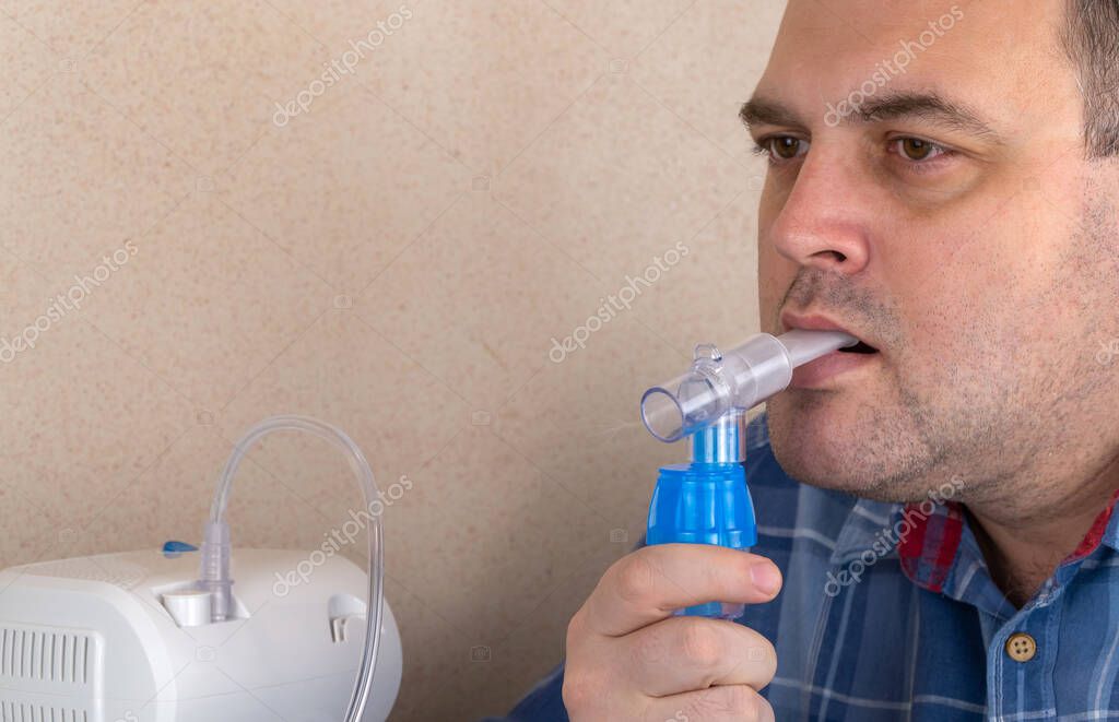 el hombre hace inhalaciones con la ayuda del nebulizador. paciente