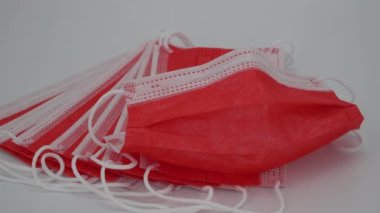Kırmızı cerrahi koruyucu maske. Beyaz arka planda tıbbi solunum bandajı var. Corona virüsüne karşı korunmak için çok renkli antiviral maske. Coronavirus COVID-19 salgını. Evde kal..