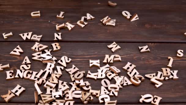 木製の背景に木製の文字 英語のアルファベット 英語の日 飛行文字だ スローモーション — ストック動画